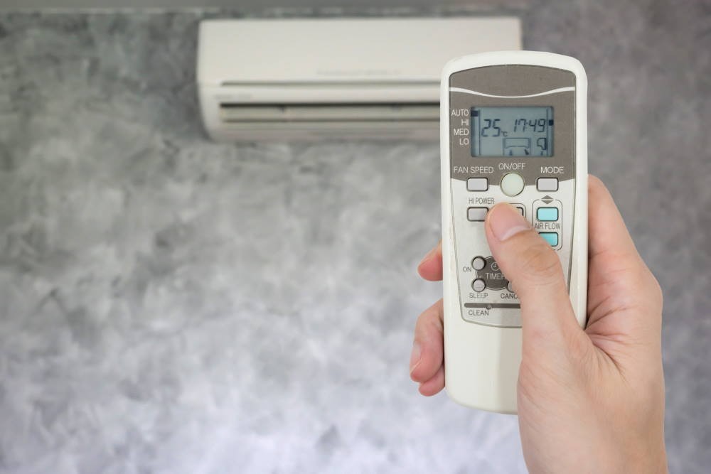 holding a remote for an air conditioning unit
